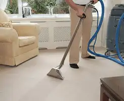 Carpet cleaning professional removing dirt and stains with a hot-water extraction tool in a home, Tucson, AZ.