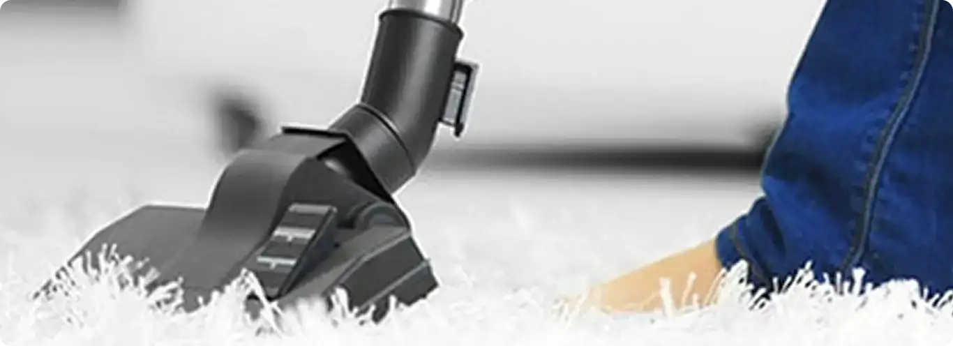 Close-up of a professional vacuuming a white carpet in Vail.