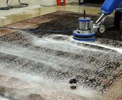 Professional rug cleaning with a rotary floor machine and shampoo foam, deep-cleaning an area rug, in Tucson, AZ.